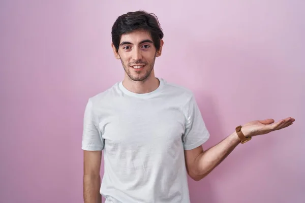 Молодий Іспаномовний Чоловік Стоїть Над Рожевим Тлом Усміхнений Веселий Подарунок — стокове фото