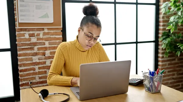 若いアフリカ系アメリカ人女性のビジネスワーカーがオフィスでノートパソコンを使って — ストック写真