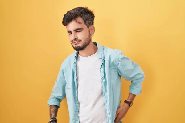 Jonge Spaanse Man Met Tatoeages Die Gele Achtergrond Staan Rugpijn — Stockfoto