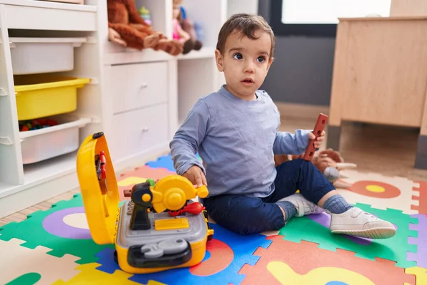 Uroczy Latynoski Chłopiec Bawiący Się Narzędziami Zabawka Siedzi Podłodze Przedszkolu — Zdjęcie stockowe