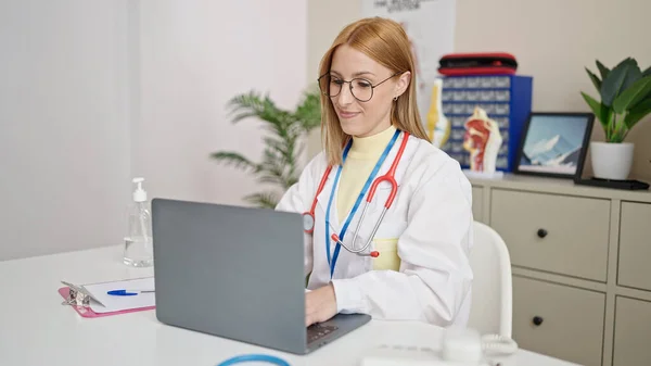 Young Blonde Woman Doctor Using Laptop Working Clinic — Zdjęcie stockowe