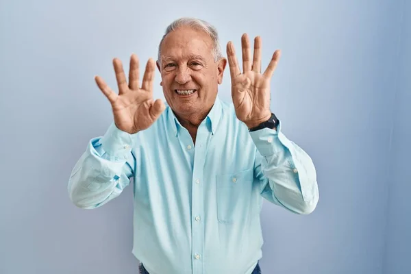 Mavi Arka Planda Gri Saçlı Yaşlı Adam Dokuz Numaralı Parmaklarıyla — Stok fotoğraf