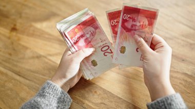 Kadın eli para sayıyor odada.