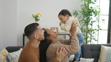 Çift ve oğul evdeki kanepede oturup birbirlerine sarılıyorlar.