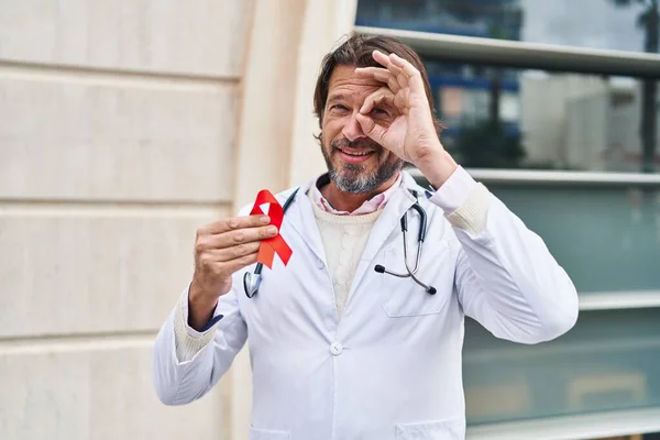 Guapo Médico Mediana Edad Hombre Sosteniendo Apoyo Cinta Roja Sonriendo —  Fotos de Stock