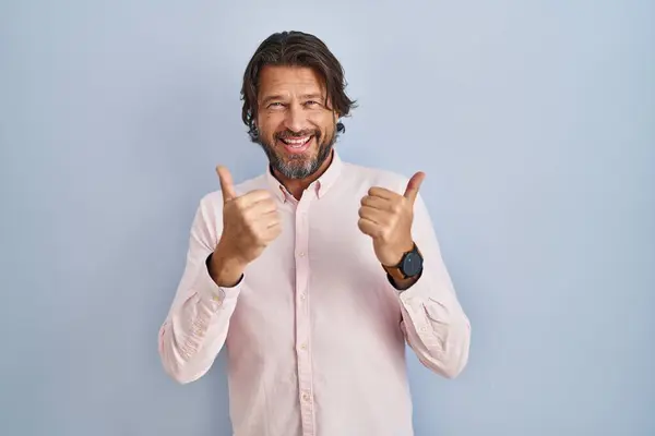 手で肯定的なジェスチャーを行うエレガントなシャツの背景の成功のサインを着てハンサムな中年の男性は 親指を笑顔と幸せ 陽気な表情と勝者のジェスチャー — ストック写真