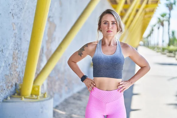 Young Blonde Woman Wearing Sportswear Standing Serious Expression Street — Stockfoto