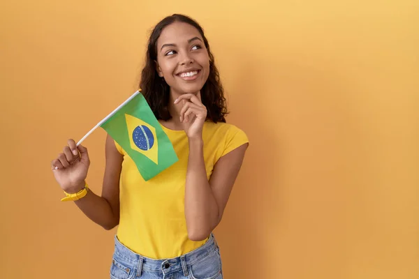 Young Hispanic Woman Holding Brazil Flag Hand Chin Thinking Question — Stock Photo, Image