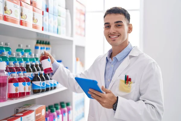 Young Hispanic Man Pharmacist Using Touchpad Holding Medication Bottle Pharmacy — Stock fotografie