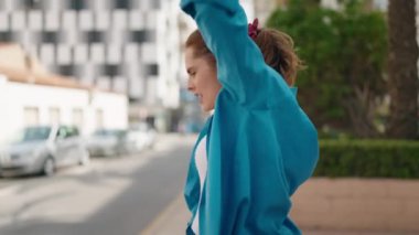 Young woman smiling confident dancing at street