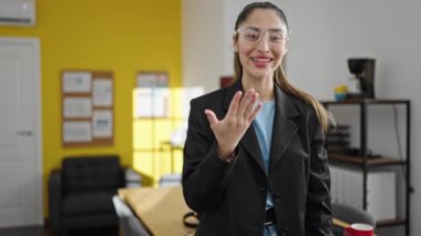 Genç, güzel İspanyol iş kadını güler yüzlü, kendine güvenen bir işadamı ofise gelip jest yapıyor.