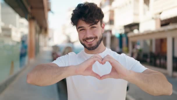 Young Hispanic Man Smiling Confident Doing Heart Gesture Hands Street — стоковое видео