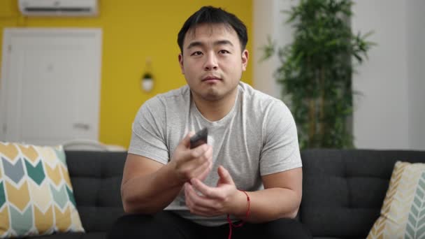 Pemuda Cina Menonton Duduk Sofa Dengan Ekspresi Membosankan Rumah — Stok Video