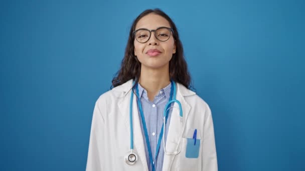 Νεαρή Όμορφη Ισπανόφωνη Γιατρός Κρατώντας Χάπια Πάνω Από Απομονωμένο Μπλε — Αρχείο Βίντεο