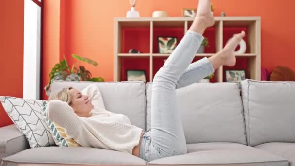 Junge Blonde Frau Lächelnd Auf Dem Sofa Liegend Die Beine — Stockvideo