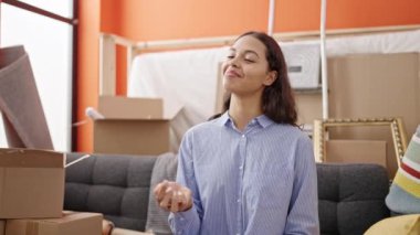 Yeni evin anahtarlarını elinde tutarak gülümseyen güzel İspanyol kadın.