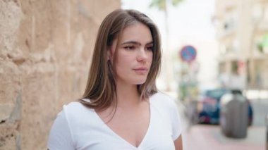 Young woman smiling confident looking to the camera at street