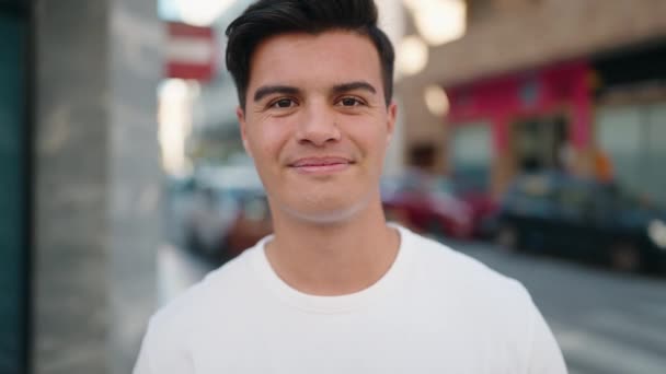 Joven Hombre Hispano Sonriendo Confiado Caminando Por Calle — Vídeos de Stock