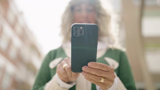 Mujer Mediana Edad Sonriendo Confiado Usando Teléfono Inteligente Calle — Vídeo de stock