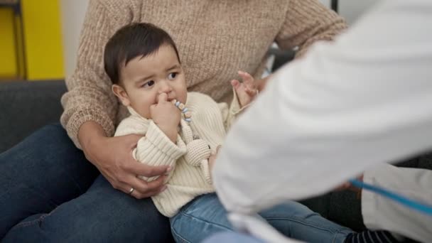 Pár Syn Vyšetřují Dítě Stetoskopem Klinice — Stock video