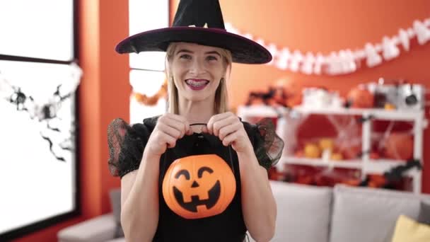 Young Blonde Woman Wearing Witch Costume Holding Pumpkin Basket Home — Stock video
