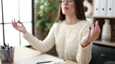 Young beautiful hispanic woman business worker doing yoga exercise at office