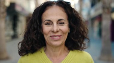 Middle age hispanic woman smiling confident at street