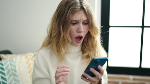 Young Blonde Woman Using Smartphone Winner Expression Home — Stock videók