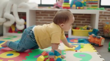Anaokulunda yerde sürünen sevimli İspanyol bebek.