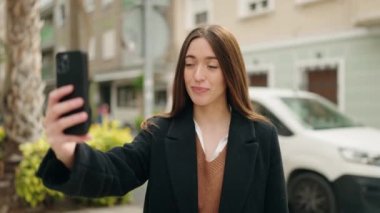 Young hispanic woman smiling confident having video call at street