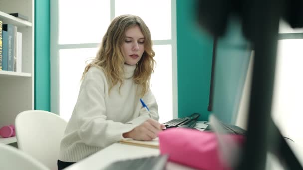 Young Blonde Woman Student Using Computer Writing Notebook Library University — Vídeos de Stock