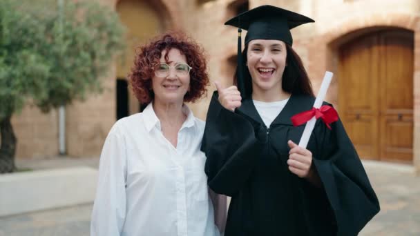 2人の女性の母親と娘を保持卒業証書を持っています大学でOkジェスチャーを行います — ストック動画