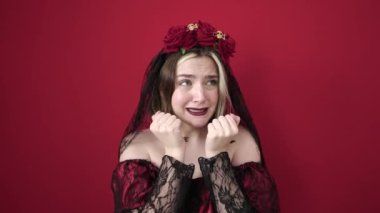 Young blonde woman wearing katrina costume doing fear expression over isolated red background