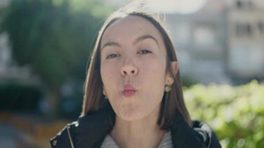 Genç, güzel İspanyol kadın gülümsüyor parkta komik jestler yapıyor.