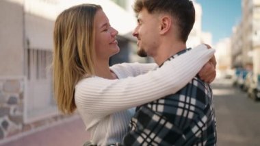 Young couple smiling confident hugging each other standing at street
