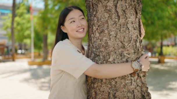 Mujer China Sonriendo Seguro Abrazando Árbol Parque — Vídeo de stock