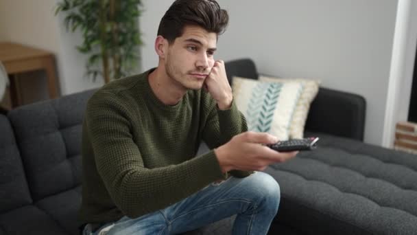 Young Hispanic Man Watching Sitting Sofa Boring Expression Home — Video Stock
