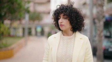 Sokakta kendinden emin gülümseyen genç bir kadın