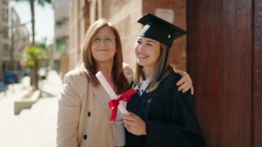 Mother and daughter hugging each other celebrating graduation at university