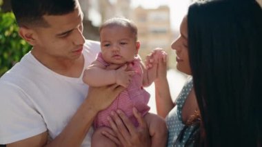 Hispanik aile sokakta öpüşürken birbirlerine sarılıyorlar.