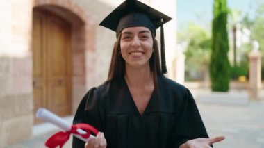 Üniversitede diploma alan, üniformalı genç İspanyol bir kadın.