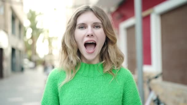 Junge Blonde Frau Steht Mit Überraschendem Gesichtsausdruck Auf Der Straße — Stockvideo