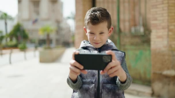 Ξανθό Παιδί Παίζει Βιντεοπαιχνίδι Από Smartphone Στο Δρόμο — Αρχείο Βίντεο