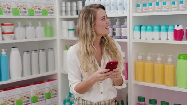 Pelanggan Wanita Pirang Muda Tersenyum Percaya Diri Menggunakan Smartphone Apotek — Stok Video
