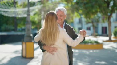 Middle age couple couple smiling confident dancing at park