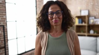 Orta yaşlı İspanyol kadın gülümsüyor.