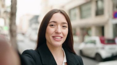 Young hispanic woman smiling confident having video call at street