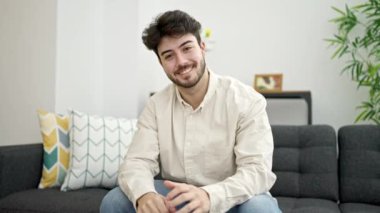 Genç İspanyol adam, evde el konuşmalarıyla merhaba diyor.