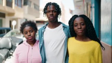 Afro-Amerikalı arkadaşlar gülümsüyor sokakta birbirlerine sarılıyorlar.