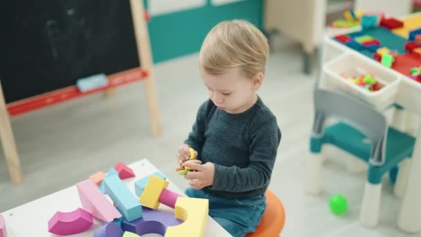 Liebenswertes Blondes Kleinkind Spielt Kindergarten Mit Geometrieblöcken Tisch — Stockvideo